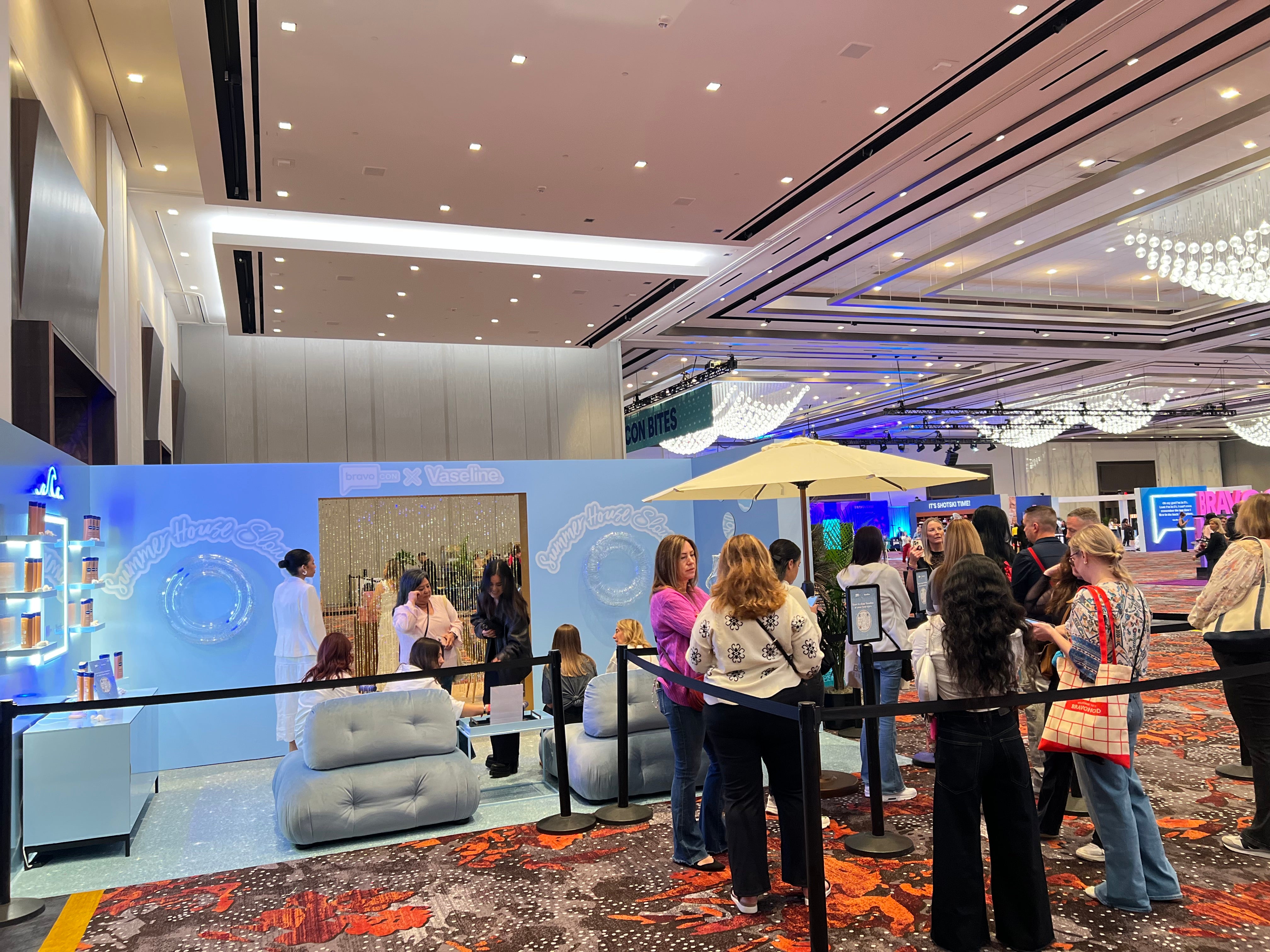 People lined up at the vaseline booth at Bravocon for permanent jewelry bracelets
