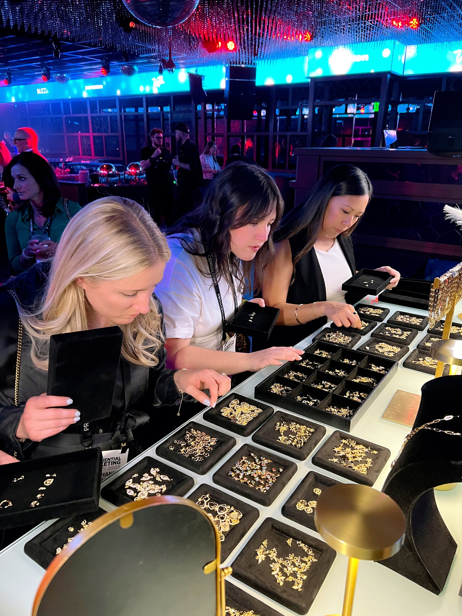 Attendees browsing a luxury interactive charm bar station setup by Hey Beautiful for a high-end corporate event activation in Las Vegas.