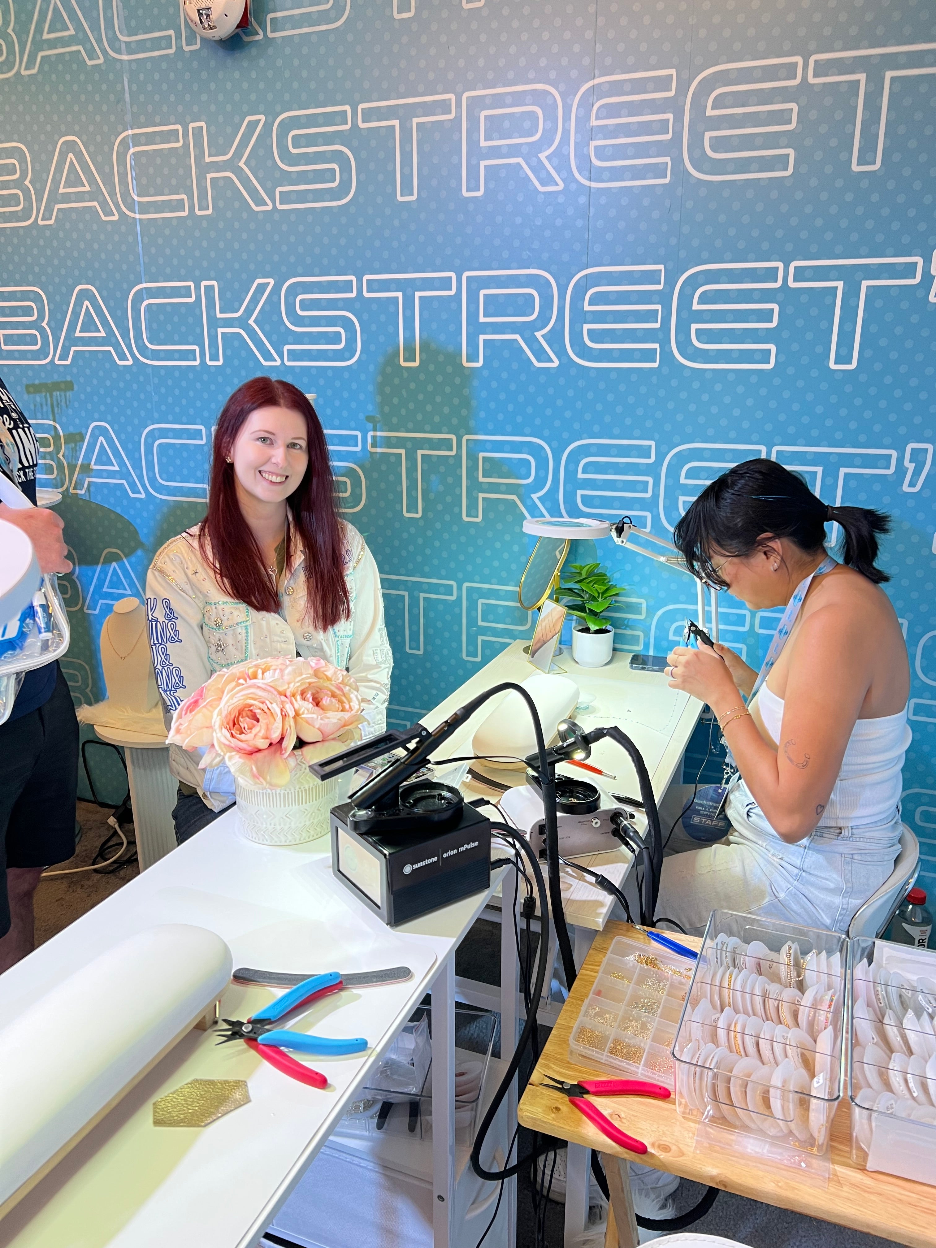 Hey Beautiful permanent jewelry activation at the Backstreet Boys fan experience in Las Vegas with guest seated at jewelry station
