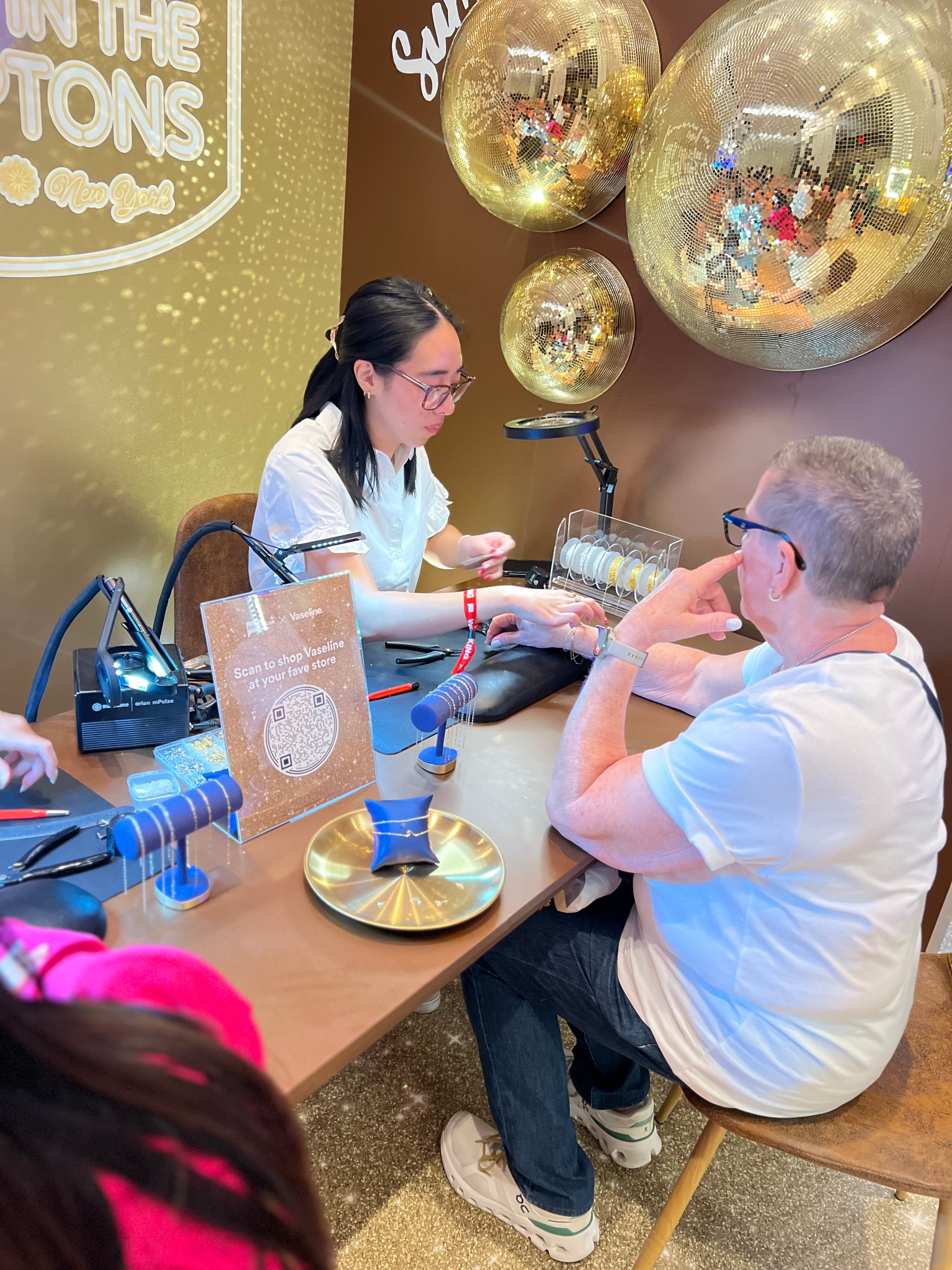 woman sizing a person for permanent jewelry bracelet