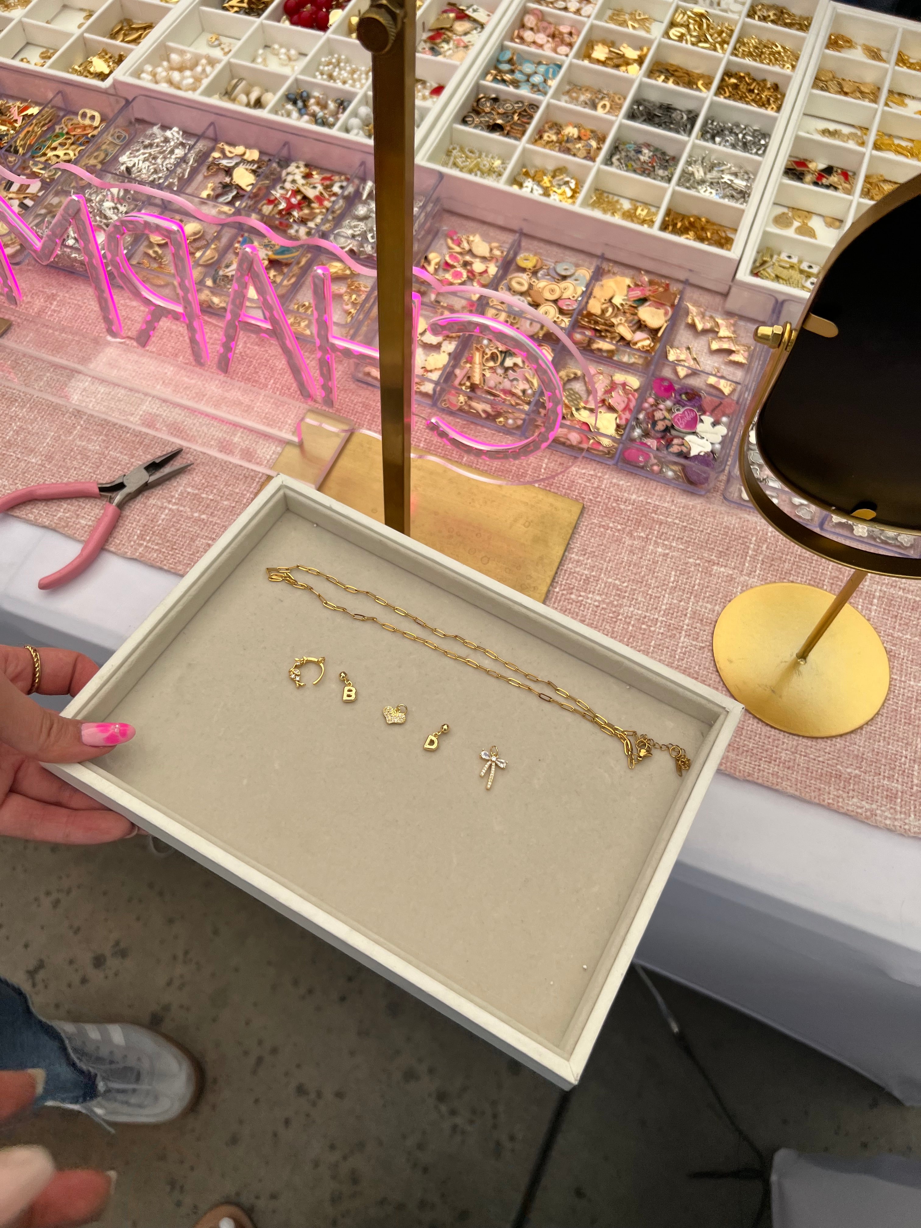 Curated charm selection shown in trays for a mobile charm bar event