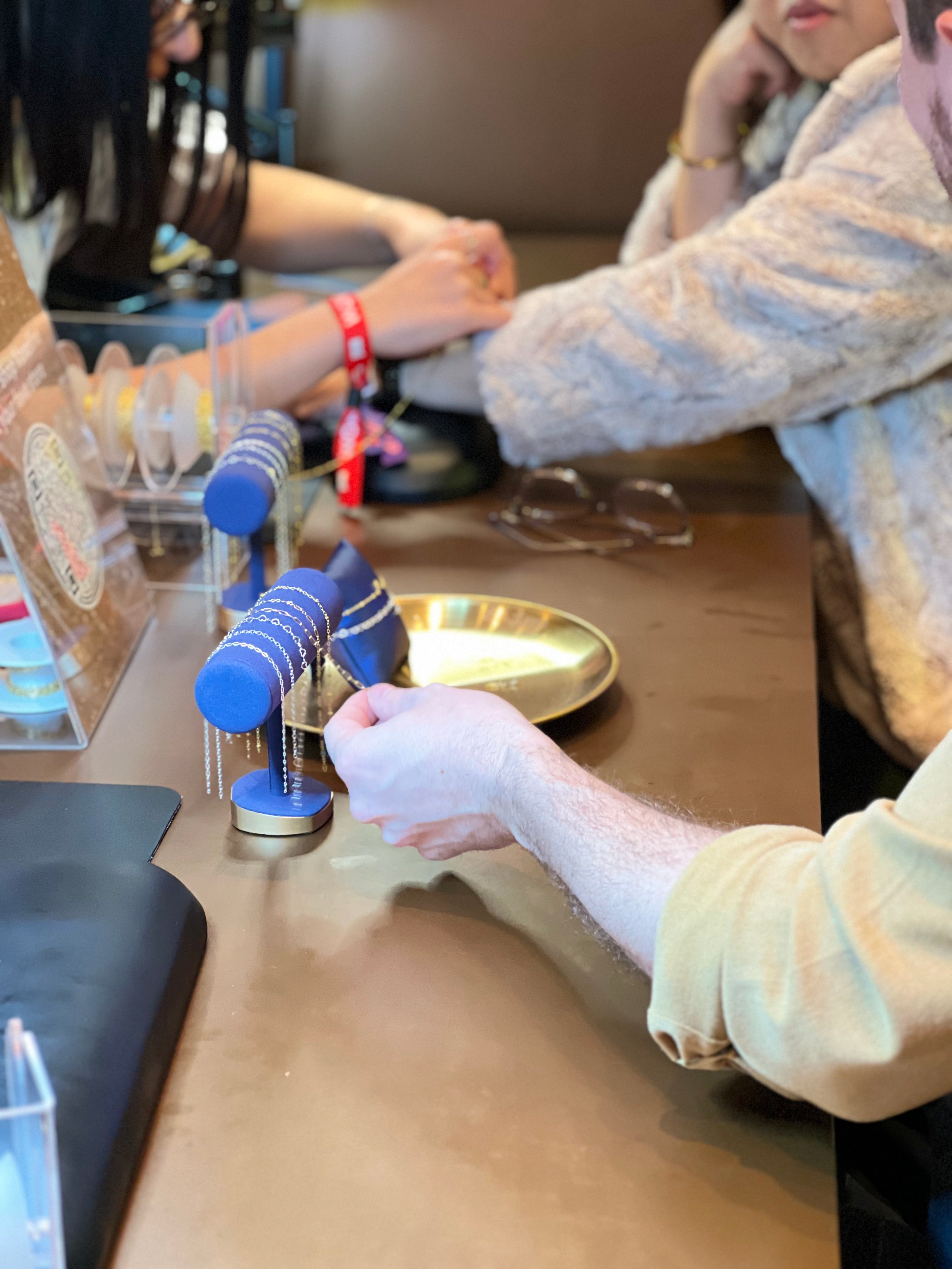 hand selecting permanent jewelry chains at a corporate event